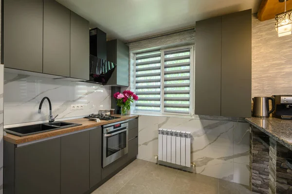 Real showcase interior of cozy designed modern trendy gray kitchen