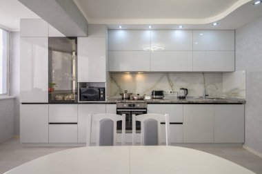 Interior of well designed modern trendy white kitchen, front view