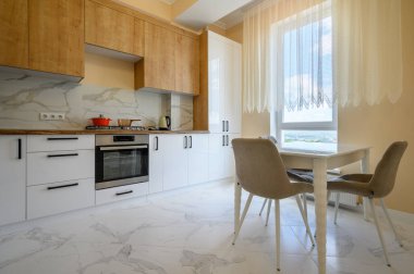 Sarı mutfak, sarı duvarlı ve beyaz mermer zeminli modern beyaz ve ahşap mobilyalar.