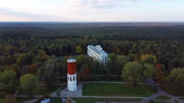 Letonya, Jurmala 'daki Kemeri Resort Parkı' nda Letonya Bayraklı Kemeri Su Kulesi. Arka plandaki güzel Beyaz Neoklasisizm Mimarlık Evi. Yukarıdan hava görüntüsü. Renkli Sonbahar Akşamı