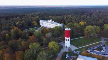 Letonya, Jurmala 'daki Kemeri Resort Parkı' nda Letonya Bayraklı Kemeri Su Kulesi. Arka plandaki güzel Beyaz Neoklasisizm Mimarlık Evi. Yukarıdan hava görüntüsü. Renkli Sonbahar Akşamı
