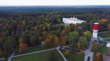Letonya, Jurmala 'daki Kemeri Resort Parkı' nda Letonya Bayraklı Kemeri Su Kulesi. Arka plandaki güzel Beyaz Neoklasisizm Mimarlık Evi. Yukarıdan hava görüntüsü. Renkli Sonbahar Akşamı