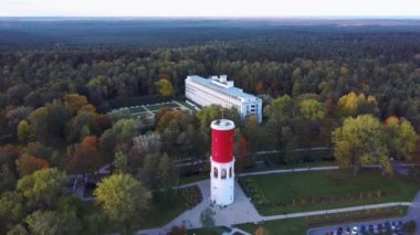 Letonya, Jurmala 'daki Kemeri Resort Parkı' nda Letonya Bayraklı Kemeri Su Kulesi. Arka plandaki güzel Beyaz Neoklasisizm Mimarlık Evi. Yukarıdan hava görüntüsü. Renkli Sonbahar Akşamı