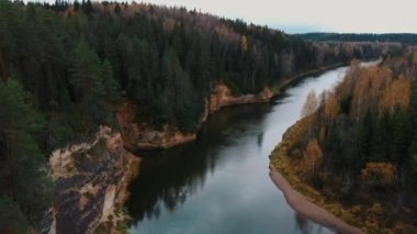 Erglu Kayalıkları ve Gauja Nehri Cesis, Letonya Büyük Manzarası. Gauja Ulusal Parkı 'ndaki Sonbahar Manzarası Kızıl Kayalar Taş Kayalıkları ve Nehir. Yukarıdan İHA ile Yakalandı. Hava Çekimi 4K.
