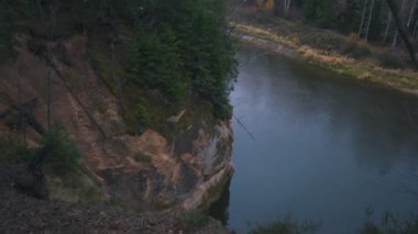Erglu Kayalıkları ve Gauja Nehri Cesis, Letonya Büyük Manzarası. Gauja Ulusal Parkı 'ndaki Sonbahar Manzarası Kızıl Kayalar Taş Kayalıkları ve Nehir. Stedicam Dolly 4K 'yı vurdu.