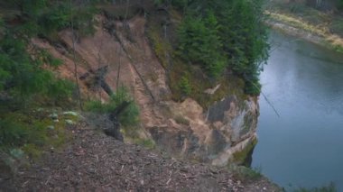 Erglu Kayalıkları ve Gauja Nehri Cesis, Letonya Büyük Manzarası. Gauja Ulusal Parkı 'ndaki Sonbahar Manzarası Kızıl Kayalar Taş Kayalıkları ve Nehir. Stedicam Dolly 4K 'yı vurdu.