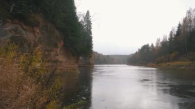Erglu Kayalıkları ve Gauja Nehri Cesis, Letonya Büyük Manzarası. Gauja Ulusal Parkı 'ndaki Sonbahar Manzarası Kızıl Kayalar Taş Kayalıkları ve Nehir. Stedicam Dolly 4K 'yı vurdu.