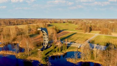 Kirkilai 'deki Modern İnşaat Gözlem Kulesi. Birzai Eldership, Panevezys County, Litvanya 'da, Sunset' te Green Nature with Pond. 4K UHD İnanılmaz Hava Dron Çekimi