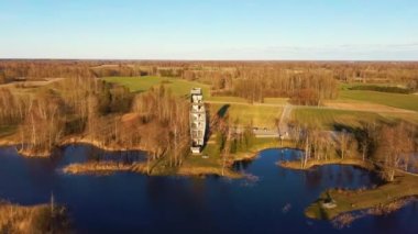 Kirkilai 'deki Modern İnşaat Gözlem Kulesi. Birzai Eldership, Panevezys County, Litvanya 'da, Sunset' te Green Nature with Pond. 4K UHD İnanılmaz Hava Dron Çekimi