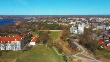 Birzai Kalesinin Hava Çekimi, Birzai Kalesi - Birzai 'de bir kale, Litvanya' daki Irvna Gölü 'nün güney kıyısında, Güneşli Bahar Günü. Tarihi Güzel Kilise ve Birzai Şehri Panoraması 4K UHD Kararı