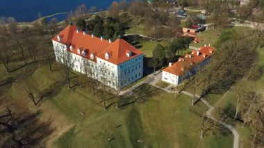 Birzai Kalesinin Hava Çekimi, Birzai Kalesi - Birzai 'de bir kale, Litvanya' daki Irvna Gölü 'nün güney kıyısında, Güneşli Bahar Günü. Tarihi Güzel Kilise ve Birzai Şehri Panoraması 4K UHD Kararı