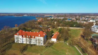 Birzai Kalesinin Hava Çekimi, Birzai Kalesi - Birzai 'de bir kale, Litvanya' daki Irvna Gölü 'nün güney kıyısında, Güneşli Bahar Günü. Tarihi Güzel Kilise ve Birzai Şehri Panoraması 4K UHD Kararı
