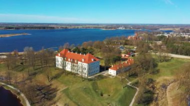 Birzai Kalesinin Hava Çekimi, Birzai Kalesi - Birzai 'de bir kale, Litvanya' daki Irvna Gölü 'nün güney kıyısında, Güneşli Bahar Günü. Tarihi Güzel Kilise ve Birzai Şehri Panoraması 4K UHD Kararı
