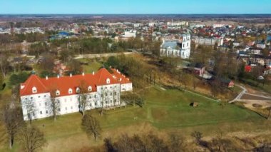 Birzai Kalesinin Hava Çekimi, Birzai Kalesi - Birzai 'de bir kale, Litvanya' daki Irvna Gölü 'nün güney kıyısında, Güneşli Bahar Günü. Tarihi Güzel Kilise ve Birzai Şehri Panoraması 4K UHD Kararı