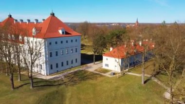 Birzai Kalesinin Hava Çekimi, Birzai Kalesi - Birzai 'de bir kale, Litvanya' daki Irvna Gölü 'nün güney kıyısında, Güneşli Bahar Günü. Tarihi Güzel Kilise ve Birzai Şehri Panoraması 4K UHD Kararı