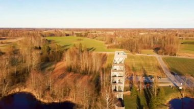 Kirkilai 'deki Modern İnşaat Gözlem Kulesi. Birzai Eldership, Panevezys County, Litvanya 'da, Sunset' te Green Nature with Pond. 4K UHD İnanılmaz Hava Dron Çekimi