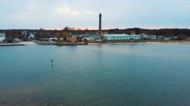 Baltık Denizi 'ndeki Engure Limanı' nda bir Corekites Kitesurfers Hidrofoiling 'in hava aracı görüntüsü. Günbatımında Kiter Biniciliğinin 4K Drone Görüntüsü. 