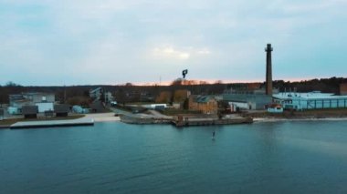 Baltık Denizi 'ndeki Engure Limanı' nda bir Corekites Kitesurfers Hidrofoiling 'in hava aracı görüntüsü. Günbatımında Kiter Biniciliğinin 4K Drone Görüntüsü. 