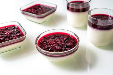 Beyaz masada ahududu soslu lezzetli panna cotta.