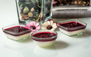 Beyaz masada ahududu soslu lezzetli panna cotta.