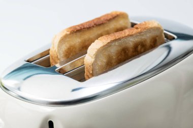 Bir dilim ekmek kahvaltı için hazırlanır. Tost makinesinin iki kızarmış ekmeği var..