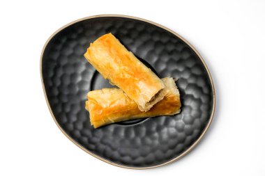 Köfteli börek, siyah oval tabakta kıyma dilimlenmiş domuz eti, kesme yolu da dahil olmak üzere beyaz arka planda izole. Üst Görünüm