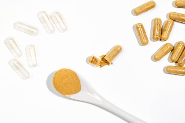 Biyolojik katkı maddeleri olan kapsüller. Bir hastalığın tedavisi olarak haplar ve kapsüller. Beyaz masa arka planında doğal takviyeler olan kapsül. Seçici odaklı Macro