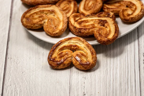 Palmier Puff Péksütemény Fehér Tányérral Egy Fehér Festett Asztalon — Stock Fotó