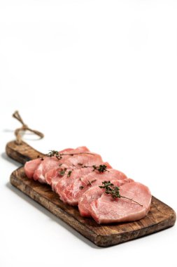 Beyaz arka planda tahta üzerinde çiğ domuz eti ve kuru fesleğen yaprağı ve baharat. Beyaza izole edilmiş taze çiğ sığır eti. Bir yığın çiğ biftek.