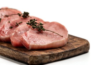 Beyaz arka planda tahta üzerinde çiğ domuz eti ve kuru fesleğen yaprağı ve baharat. Beyaza izole edilmiş taze çiğ sığır eti. Bir yığın çiğ biftek.