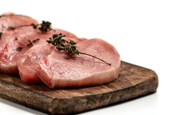 Beyaz arka planda tahta üzerinde çiğ domuz eti ve kuru fesleğen yaprağı ve baharat. Beyaza izole edilmiş taze çiğ sığır eti. Bir yığın çiğ biftek.