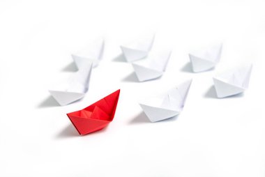 Kırmızı ve beyaz kağıt tekneler. Takım çalışması için liderlik gemisi kavramı veya başarı.