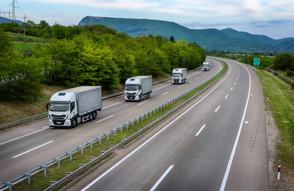 Four White Trucks Line Country Highway — Zdjęcie stockowe