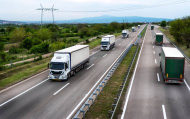 Otoyoldaki beyaz kamyonlar. Akşamları otoyolda ağır kamyon trafiği.