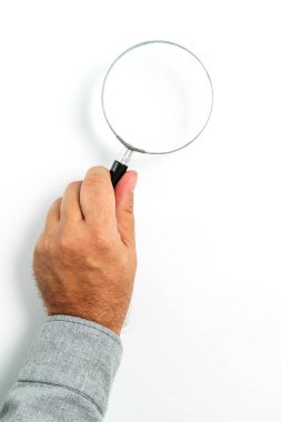 Adamın eli, klasik bir büyüteç tutuyor, yakın plan beyaz arkaplanda izole edilmiş, resim veya metin için kopyalama alanı