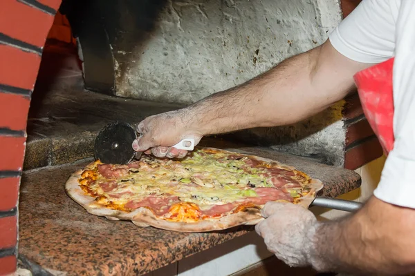 Koch schneidet Pizza — Stockfoto