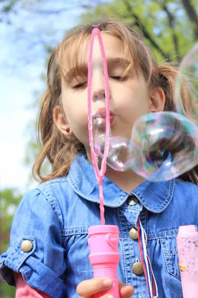 Chica soplando burbujas — Foto de Stock