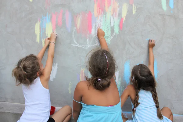 Duvara renkli tebeşirle resim çizen çocuklar — Stok fotoğraf