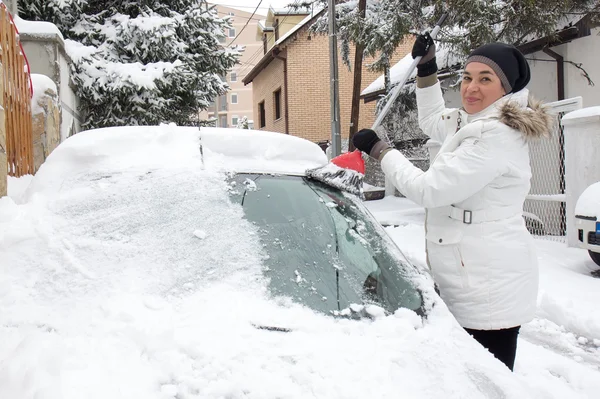 Žena úklid sněhu z auta — Stock fotografie