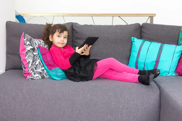 Girl on the couch with tablet — Stock Photo, Image