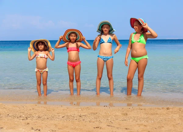 Mädchen mit bunten Hüten am Strand — Stockfoto