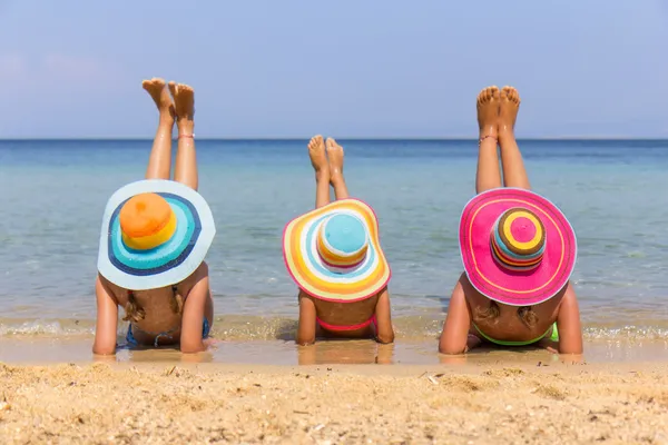 Meisjes met kleurrijke hoed op het strand — Stockfoto