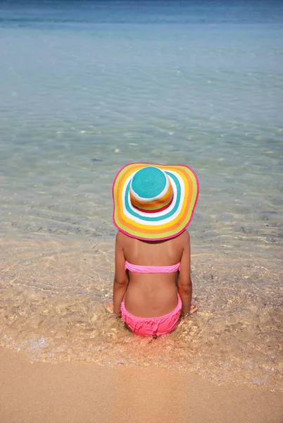 Menina com chapéu colorido na praia — Fotografia de Stock