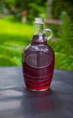 Masada zarif bir şişe gül şarabı var.