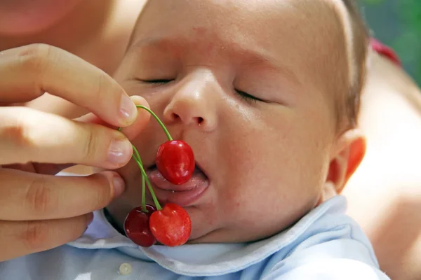 Baby knabbert Kirschen — Stockfoto