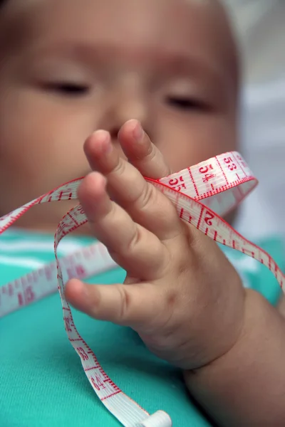 Baby hält Maßband — Stockfoto