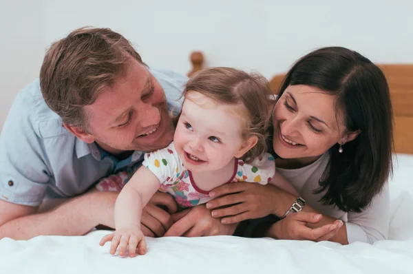 Lycklig familj i sängen — Stockfoto