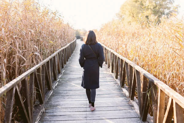 Young Woman Walking Long Wooden Path Stock Photo