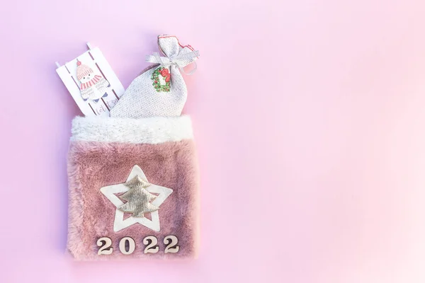 Pembe arka planda hediyeler olan Noel çantası.