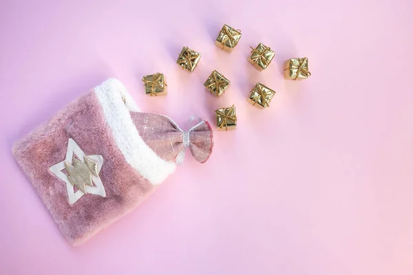 Pembe arka planda hediyeler olan Noel çantası.